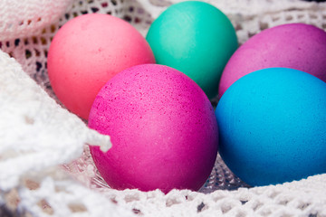 Colored Easter eggs on a white lace napkin