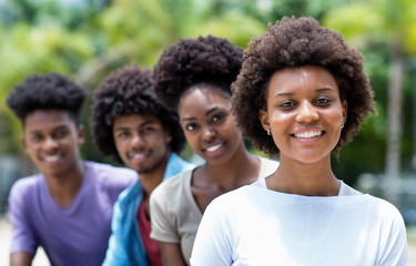 Happy african american woman with group of young adults in line