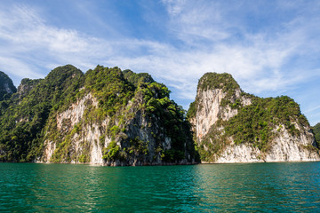Naklejka na ściany i meble Beautiful nature rock mountains cliff and blue emerald water color lake river with blue clear sky in Ratchaprapa Dam at Khao Sok National Park, Surat Thani Province, Thailand. Asia tourism location.