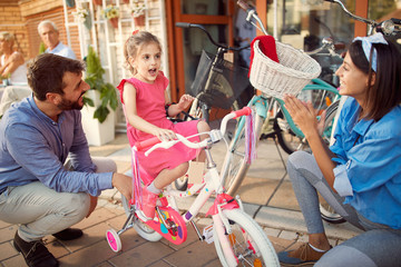 Young father buys daughter new bicycle in bike shop.