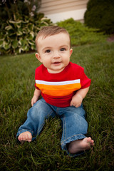 Happy Baby Boy Sitting in Grass Outside - Color Portrait