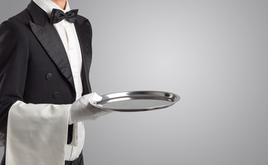 Waiter serving with white gloves and steel tray in an empty space

