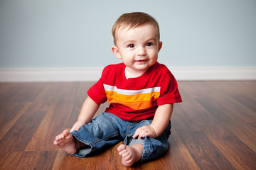 Happy Baby Boy Sitting on Wood Floor in Home - Color Portrait