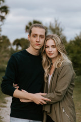 Obraz premium Romantic and Loving Young Adult Couple at the Park Looking At Nature and the Horizon for Portrait Pictures
