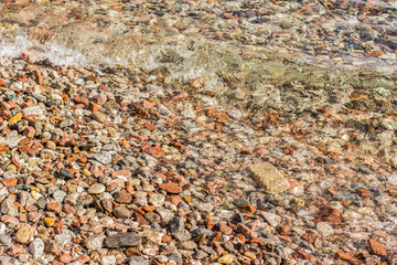 bright colorful stones in empty beach without people, summer vacation and travel to exotic countries concept background texture photography from above