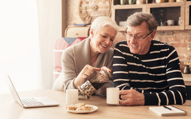 Happy senior couple drinking tea in kitchen