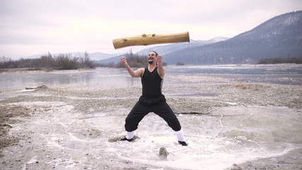 Man throw heavy log in the air while exercising