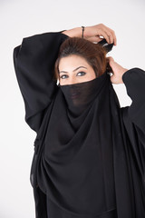 Naklejka premium Beautiful Arab woman in traditional dress covering her face