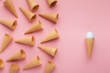 Waffle cones and easter egg on pink surface