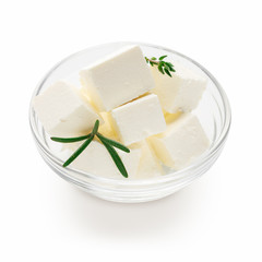 Feta cheese cubes in bowl on white