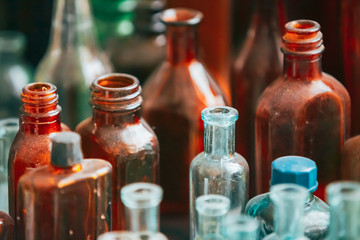 Many Old Medical  Glass Capacity. Detail Of Retro Chemical Pharmaceutical Science Researches. Many Small Vintage Bottles And Glassware Different Sizes And Colors
