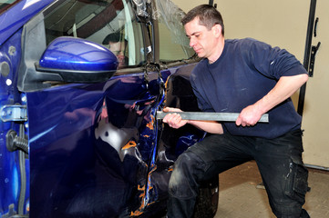 Mechanic trying to open damaged door.
