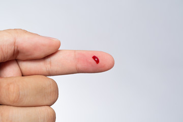 Bleeding blood from the cut finger wound. Injured finger with bleeding open cut wound. Closeup of...