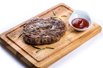 big steak on a wooden board with sauce