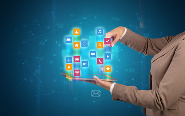 Female elegant hand holding tablet with colourful application icons