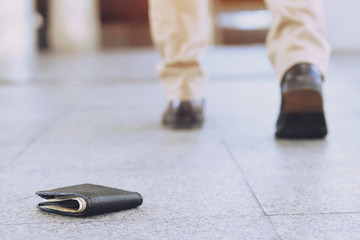 businessman had lost leather wallet with money on the street. Close-up of wallet lying on the...