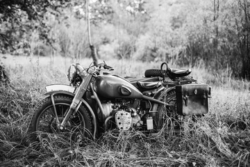 Foto op Plexiglas Old Tricar, Three-Wheeled Motorbike Of Wehrmacht, Armed Forces Of Germany Of World War II Time In Summer Forest. Photo In Black And White Colors © Great Brut Here