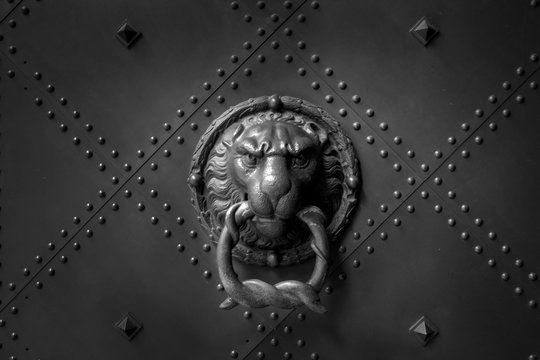 Close-up of antique lion headed door knocker on old vintage metal door. Security concept. - Image