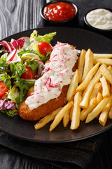 Lunch menu fried pollock with french fries and fresh salad close-up on a plate and sauce. vertical