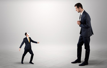 Fototapeta premium Conflict between small masked businessman and big elegant businessman 