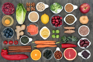 Super food to slow the ageing process concept including fish, fruit, vegetables, herbs, spices, supplement powders, green tea and dairy. High in antioxidants, anthocyanins, dietary fibre and vitamins.