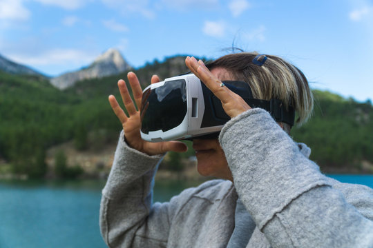 Woman in the nature wearing augmented reality goggles.