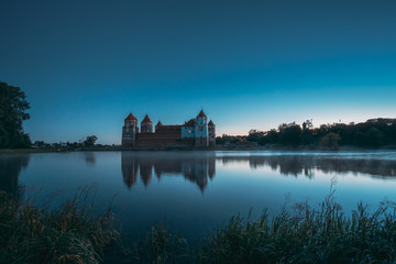 Mir, Belarus. Mir Castle And Lake During Early Summer Morning Time. Cultural Monument, UNESCO World Heritage Site. Famous Landmark And Popular Destination