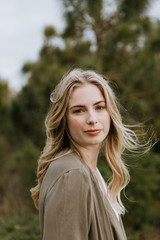 Pretty Young Beauty Woman Model with Gorgeous Long Blond Hair Blowing in the Wind Smiling for Portrait Shots Outside at the Park