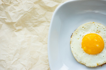 Round fried egg in the plate.