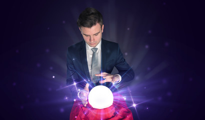 Young businessman sitting with crystal ball in action