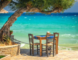 Table under the three by the blue sea