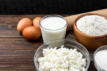 Corn sticks, corn and corn flakes on dark wooden background.