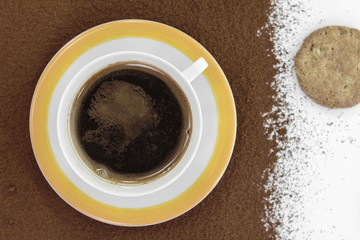 top view of cup of black coffe and biscuits put it on milled coffee background. White cup of black coffee. Coffee background. 