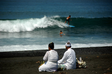 An Elderly Balinese Couple Getting Ready for Morning Ritual on a Beach