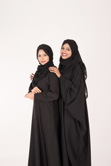 Arab women in traditional dress standing on white background