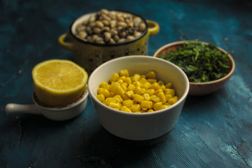 Dry cowpea salad ingredients; cowpea, lemon, parsley on blue background. Vegetarian food concept