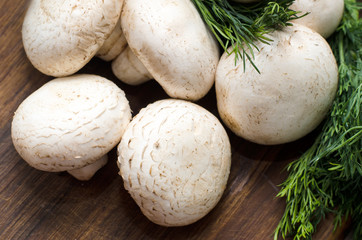 Fresh raw champignon on wooden cutting board