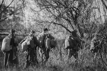 Re-enactors Dressed As World War II Russian Soviet Red Army Soldiers Marching Through Forest In...