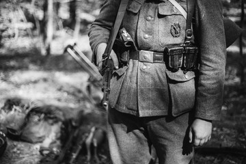 Re-enactor Dressed As World War II German Wehrmacht Soldier Holds Soviet Rifle. Photo In Black And White Colors. Military German Soldier In Uniform Of WWII Times