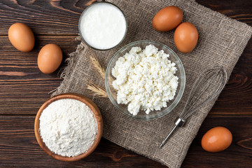 Ingredients for preparation cottage cheese pancakes. Cottage cheese, eggs, milk, sugar and flour. 