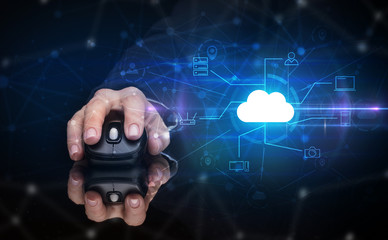 Hand using wireless mouse in a dark environment with cloud technology and online storage concept