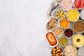 Canned food on stone background, top view with copy space - obrazy, fototapety, plakaty