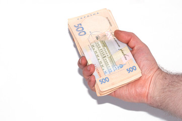 Money in male hand on a white background, Ukrainian hryvnia a large bundle of bills, close-up, copy space