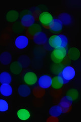 Colored lights (garland) in the dark. Bokeh effect Festive illumination.