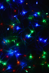 Colored lights (garland) in the dark. Bokeh effect Festive illumination.