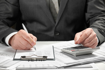 Businessman working in an office. Hands and documents closeup.
