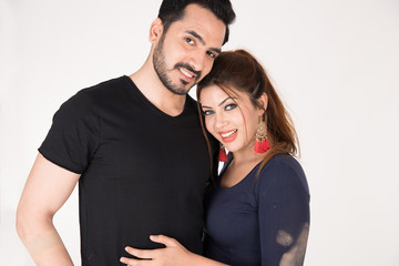 young couple together posing on white background