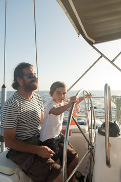 Father and son floating on expensive boat on sea and blue sky in sunny day