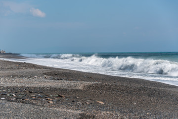 Volcanic Black Sand Beach and Blue Ionian Sea in Sicily