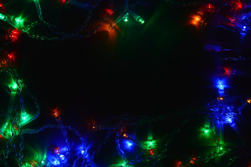 Colored lights (garland) in the dark. Bokeh effect Festive illumination.